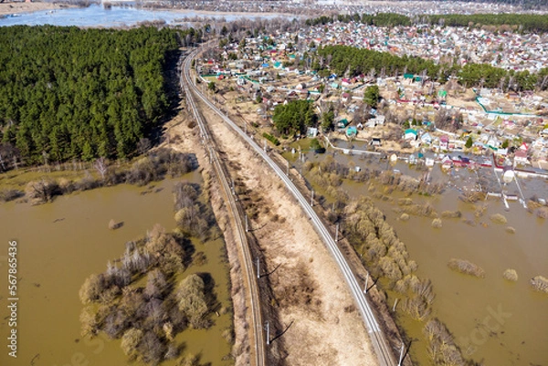 Fototapeta Railway tracks passing through the flooded area and rural areas, aerial view