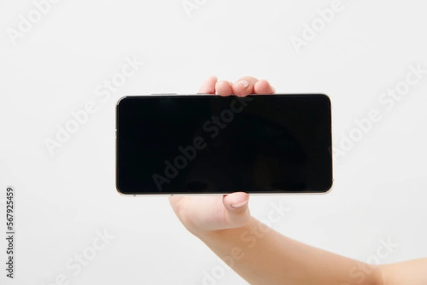 Obraz 가로로 휴대폰을 들고 있는 여성의 손