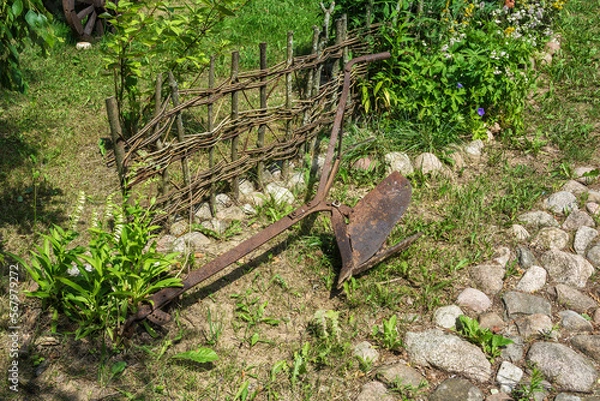 Obraz Old rusty plow for plowing the ground lying on the grass