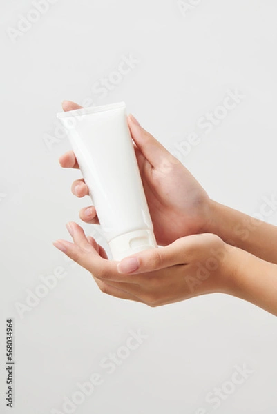 Obraz 두손으로 흰색 목각 화장품 용기를 손에 받친 여성의 손