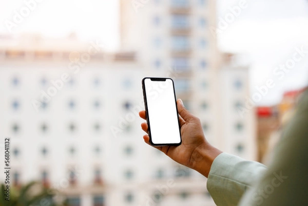 Obraz Afro american woman using a smartphone with white screen for mock up design.