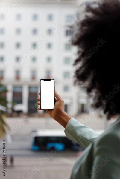 Obraz Afro American woman using a smartphone with a white screen for mock-up design. Vertiical