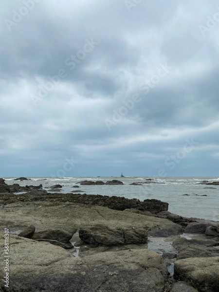 Fototapeta a serene beach and small rocks. The clear blue sea and sky make for a perfect summer landscape, perfect for travel and tourism. Relax and enjoy the calming atmosphere of this coastal paradise