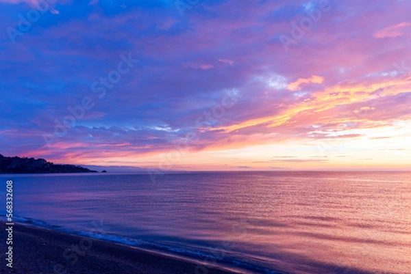 Fototapeta view at sunrise or sunset in sea with nice beach , surf , calm water and beautiful clouds on a background of a sea landscape