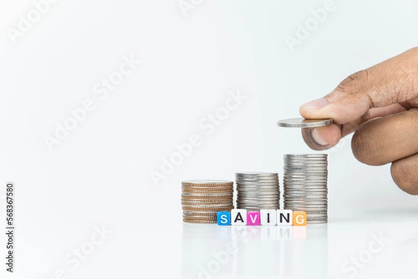 Fototapeta hand putting a coin on stacks of coin, money saving concept, financial and business growth concept, white background, copy space.