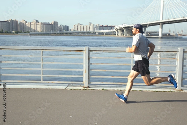 Obraz The athlete runs along the embankment of the Gulf of Finland
