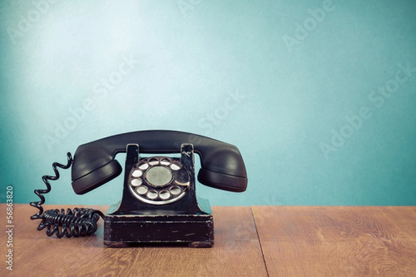 Obraz Retro telefon na stole przed miętowym zielonym tłem