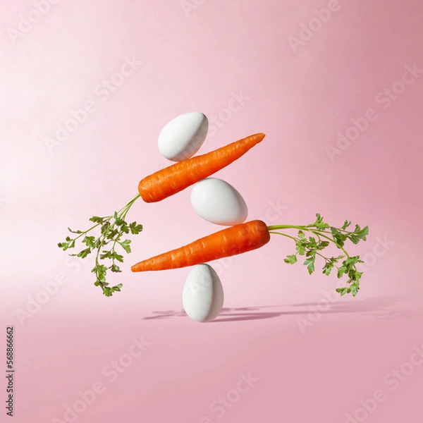 Obraz Creative composition with carrots and eggs on pastel pink background. Balanced diet concept.