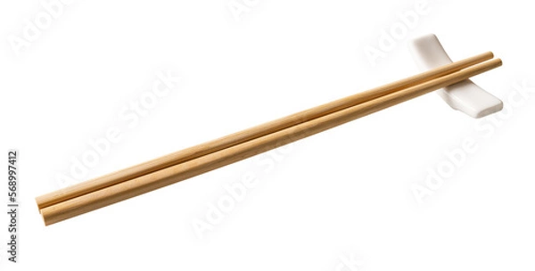 Obraz Wooden chopsticks on a white chopstick rest cutout. Pair of bamboo chopsticks on a porcelain holder  isolated on a white background. Japanese, Chinese, East Asian tableware concept.