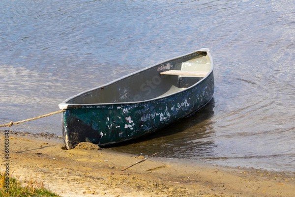 Obraz Old battered canoe tied up on a beach