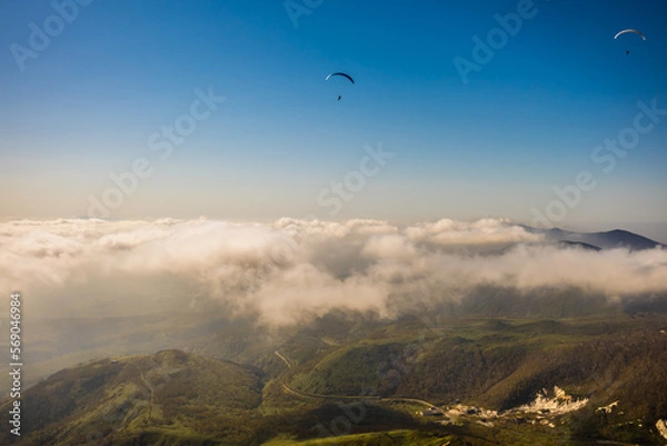 Obraz 北海道のニセコ上空で曇より高く飛ぶパラグライダーを空撮