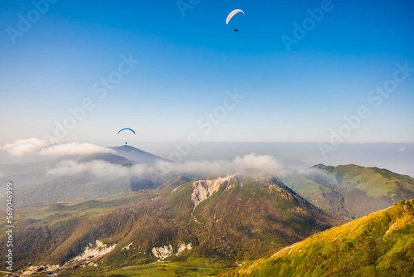 Obraz 北海道のニセコ上空で雲より高い所を飛ぶパラグライダーを空撮