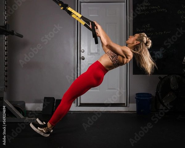Fototapeta Woman doing a modified pullup.