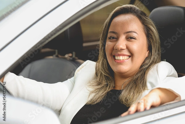 Obraz Uma mulher como motorista dentro de um carro de cor prata que está muito feliz e sorrindo para a câmera. Pessoa, Transporte, Veículo.