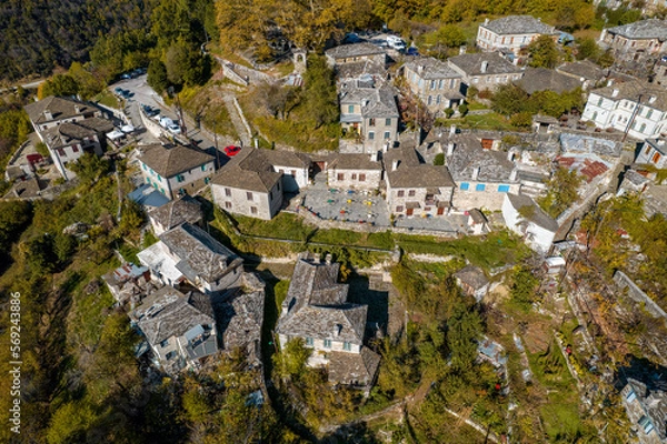 Fototapeta aerial view of the traditional village Mikro Papigo with with stone buildings and  astraka mountain as background during  fall season in  zagori Greece