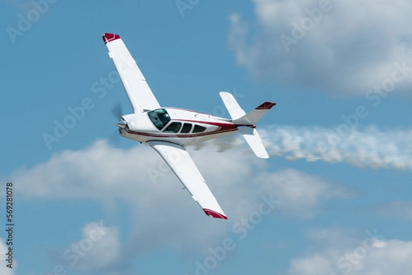 Fototapeta Small propeller plane flying with smoke at an airshow in the USA. 