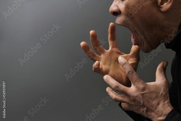 Fototapeta man screaming and shouting with anger on grey background with people stock photo	 