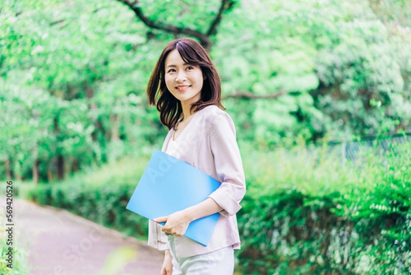 Fototapeta 書類を持って歩く若いビジネスウーマン