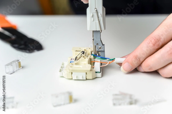 Fototapeta installing a network cable into a prefabricated RJ45 module using the LSA punch down tool, ethernet socket
