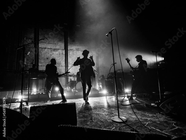Obraz silhouette of a person in a band walking up to a microphone