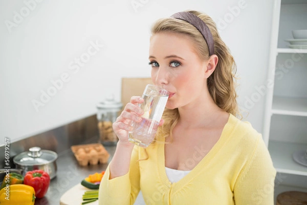 Fototapeta Content cute blonde drinking a glass of water