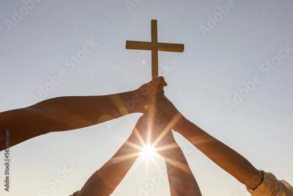 Fototapeta Christian, Christianity, Religion copy space background. Group hands praying and holding christian cross for worshipping God at sunset background.silhouette