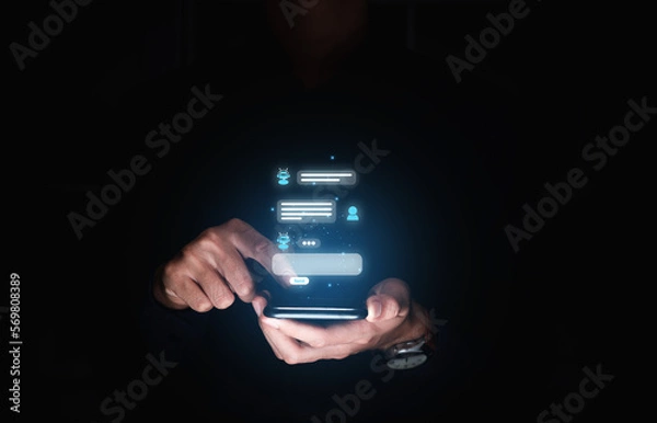 Fototapeta Hand of businessman using smartphone chatting with chat bot,  Chat with AI or Artificial Intelligence technology.