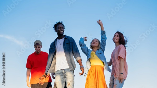 Fototapeta Group of multiracial friends having fun in the park outside dancing together - together again