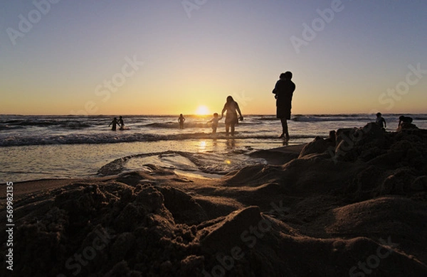 Obraz niños y sus padres corriendo hacia el mar al atardecer