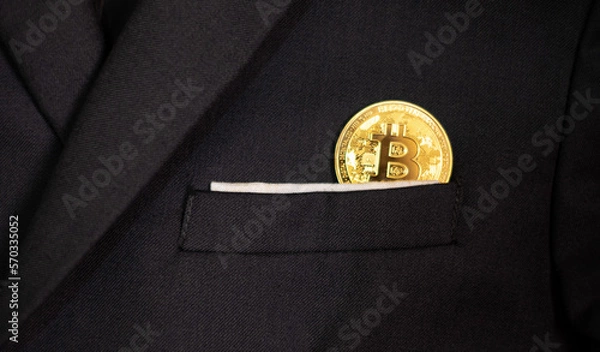 Fototapeta bitcoin in a business man black suit pocket, a concept of future investment and block chain technology