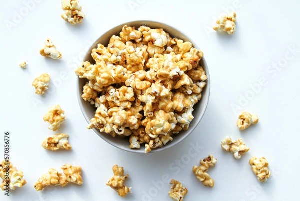 Fototapeta Caramel popcorn in a bowl, on a white background