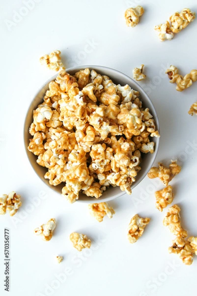 Fototapeta Caramel popcorn in a bowl, on a white background