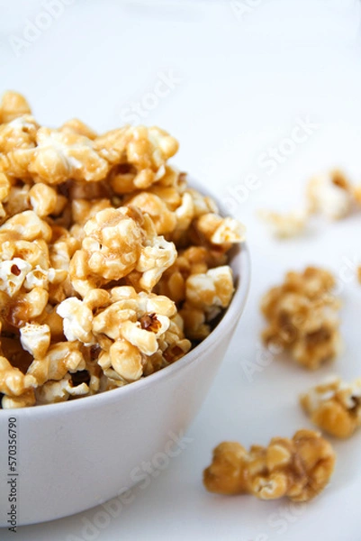 Fototapeta Caramel popcorn in a bowl, on a white background