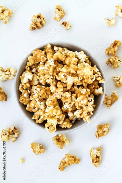 Fototapeta Caramel popcorn in a bowl, on a white background