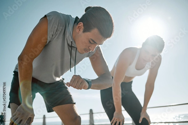 Fototapeta Fitness, tired couple and running time on blue sky for health and wellness outdoor. Man and woman in nature for workout performance and healthy lifestyle for body fatigue with lens flare and progress