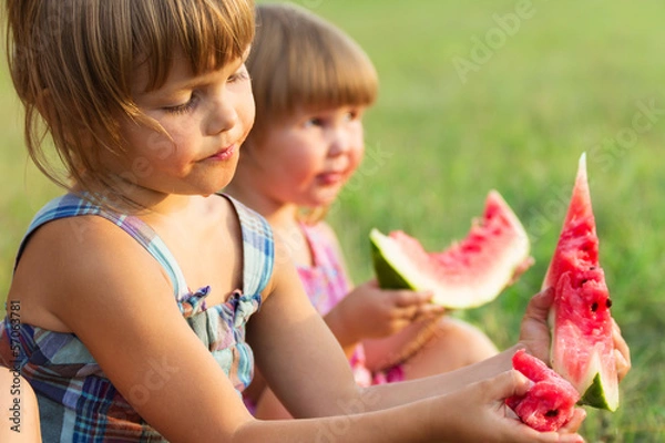 Fototapeta Girls eat sweet and tasty water-melon