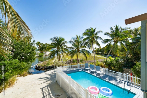 Fototapeta Above ground pool with composite wood deck with ocean view.