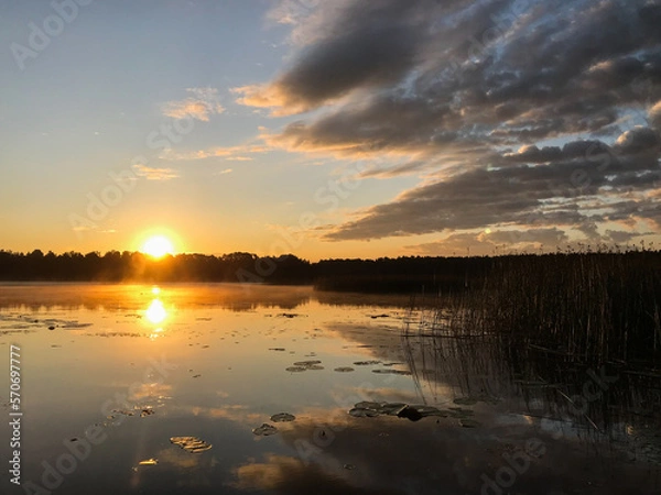Obraz Sunset on a lake with blue skies and clouds reflecting in the water. Tourism and travel concept.