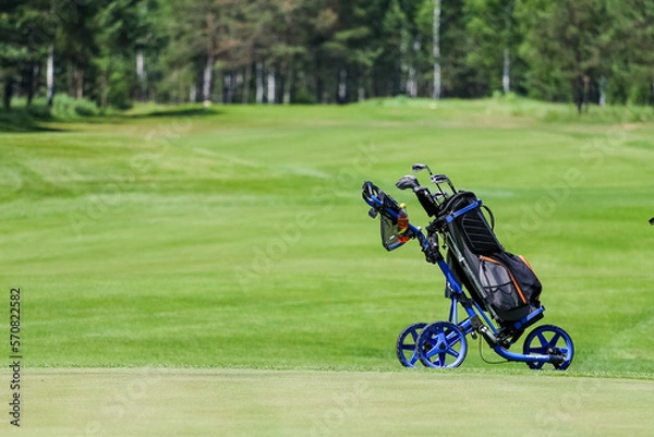 Fototapeta The Golf club bag for golfer training and play in game with golf course background , green tree rays. 