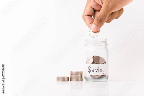 Fototapeta hand putting  money coin into piggy bank with white background, saving money concept, copy space