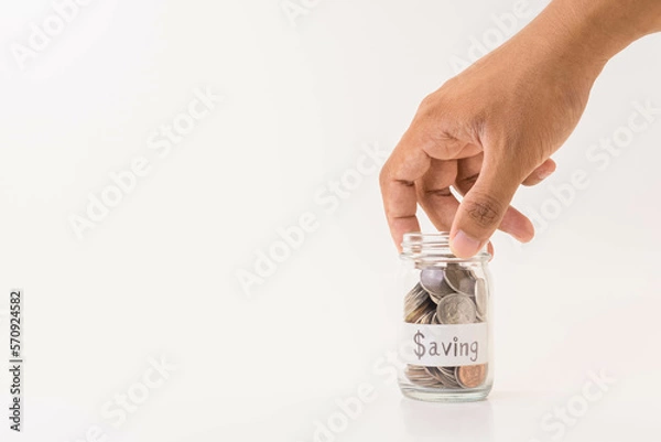 Fototapeta hand picking up a piggy bank with white background, saving money and financial concept, investment idea, copy space
