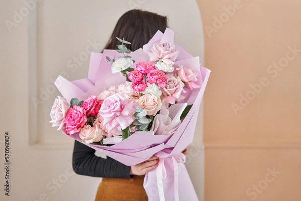 Fototapeta Young woman making fashion modern bouquet in korean style of different flowers. colorful color mix flower. Floral shop concept. Flowers delivery