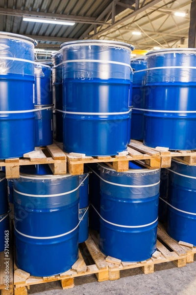 Obraz Blue metal barrels stacked in a Warehouse, vertical photo.