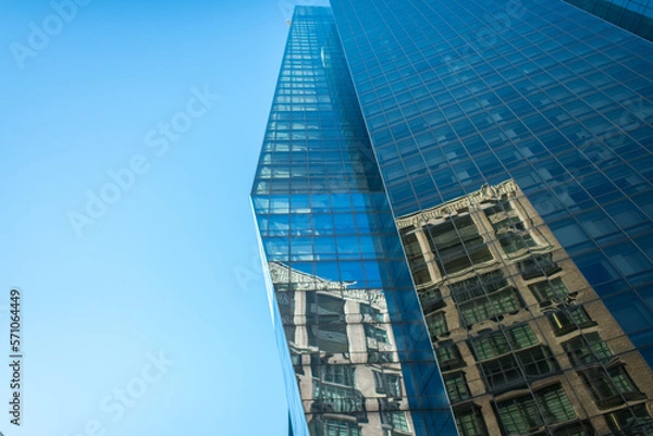 Obraz Old city building reflecting off of new modern building widnow