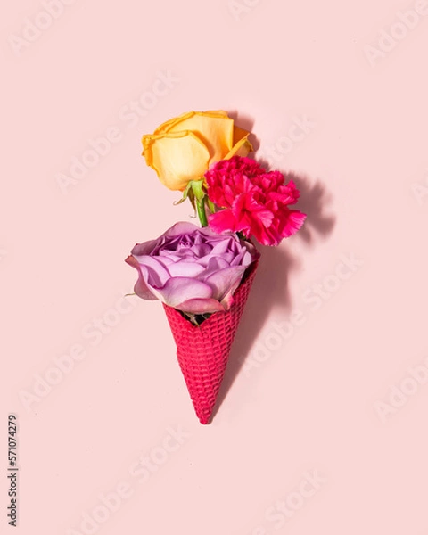 Fototapeta Pastel flowers in ice cream cone on light pink background. Creative food concept. Minimalistic nature composition. Sunny summer day idea. 8th march idea.