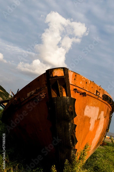 Fototapeta Abandoned fishing boat. Its rustic surface changed to a charming tone at sunset.