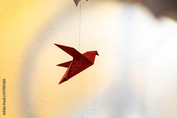 Fototapeta Japanese folded Origami cranes hanging on with strings. Hundreds handmade paper birds isolated with copy space. 1000 thousand crane sculpture topic. Symbol of peace, faith, health, wishes, hope