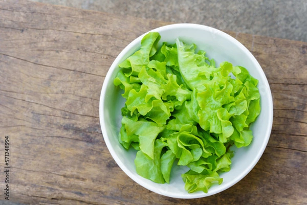 Fototapeta Leafy greens or lettuce in white bowls that are commonly used in salads or eaten fresh. Healthy food concept.