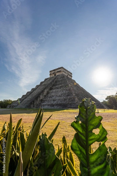 Fototapeta Photo of the pyramid in Chichen Itza taken through the plants.