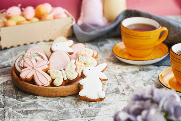 Fototapeta Aesthetics Easter glazed cookies and cup of tea on the decorated holiday table